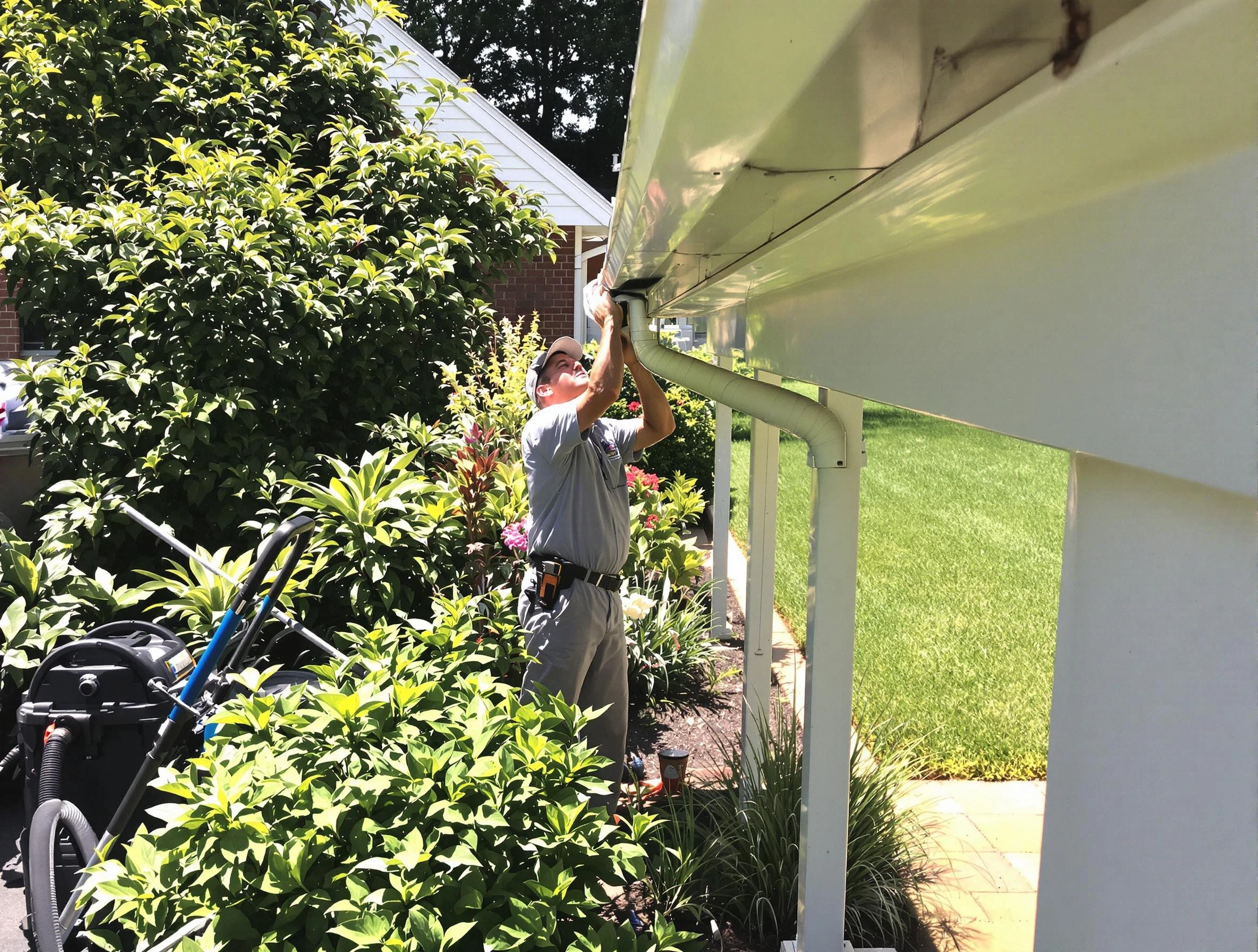 Technician flushing a blockage from a downspout in Lakewood, OH